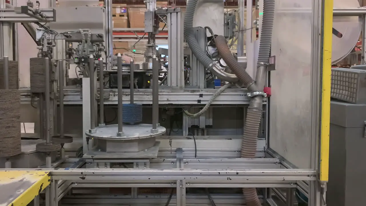 Low angle static time-lapse of a production machine making flap disks