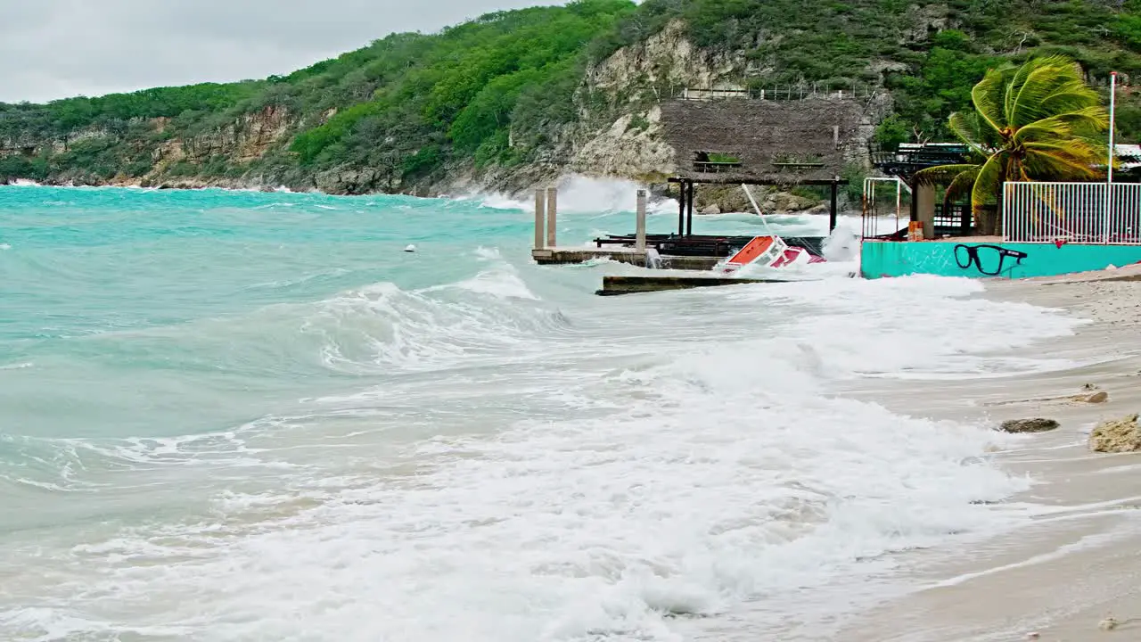 Wide of local wooden fishing boat being smashed into pieces during sudden storm with rough waves Caribbean