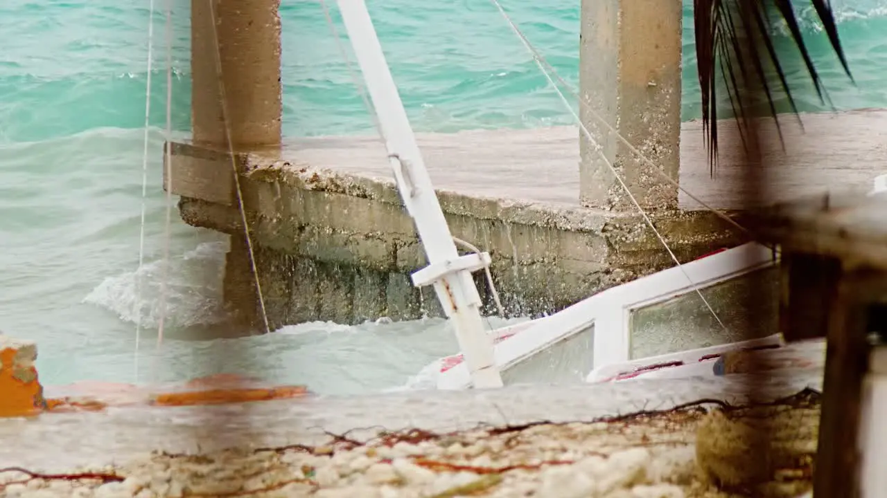 Close up of local wooden fishing boat being smashed into pieces during sudden storm with rough waves Caribbean