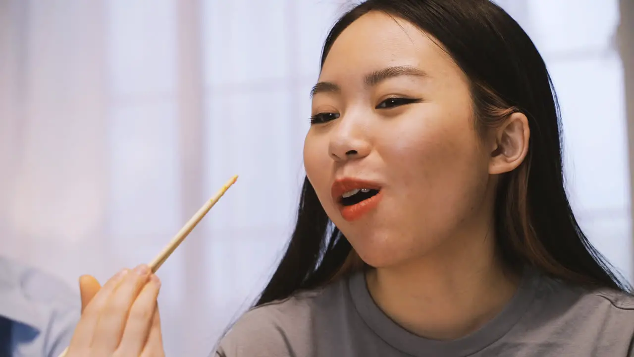 Close Up View Of Japanese Woman Holding Chopsticks Picking Wasabi While Laghing In The Kitchen