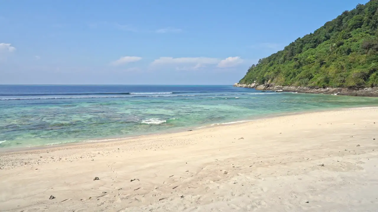 Slow-motion of waves coming into a deserted white sand beach