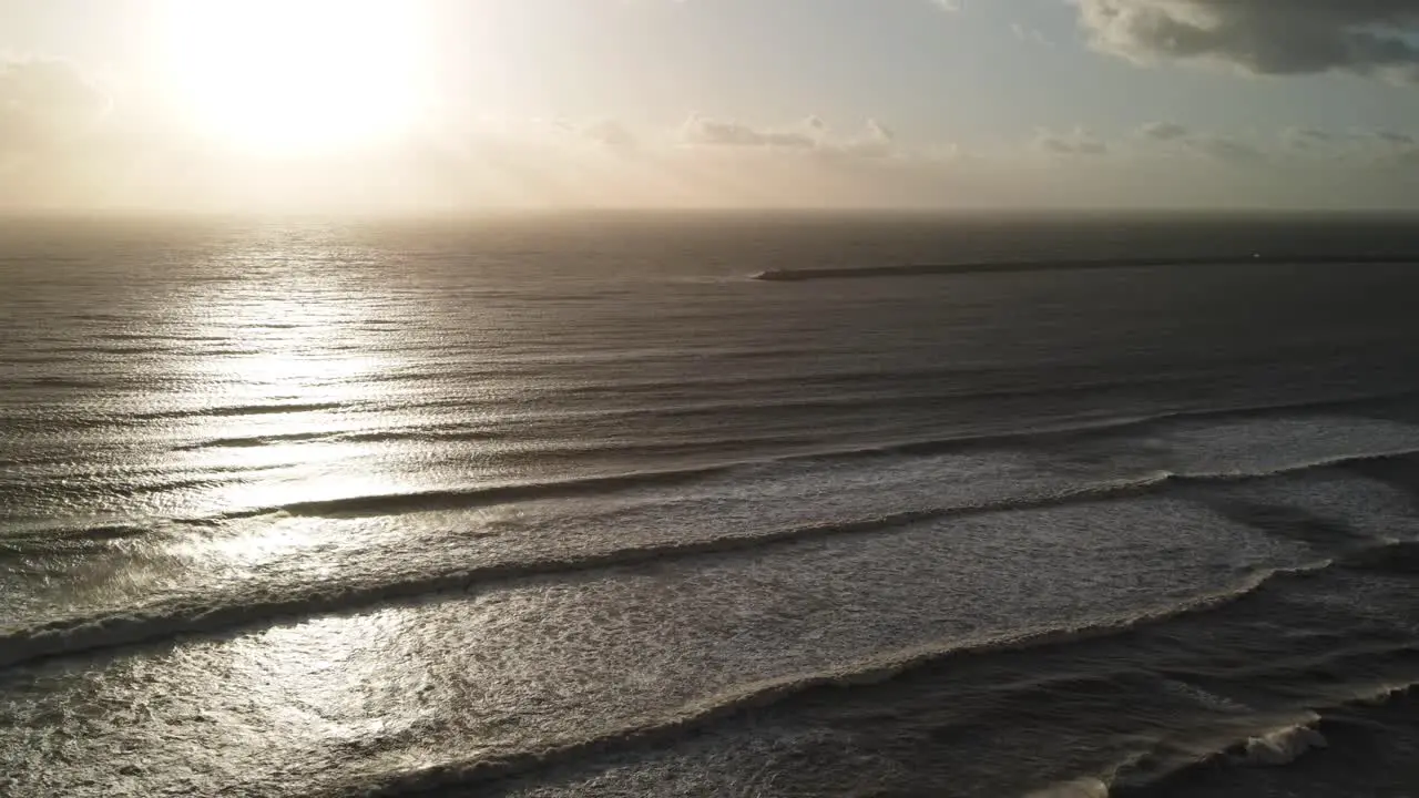 Ocean waves at sunset view from drone