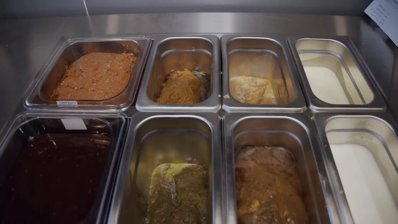 Food ingredients inside metal storage tray on restaurant kitchen table