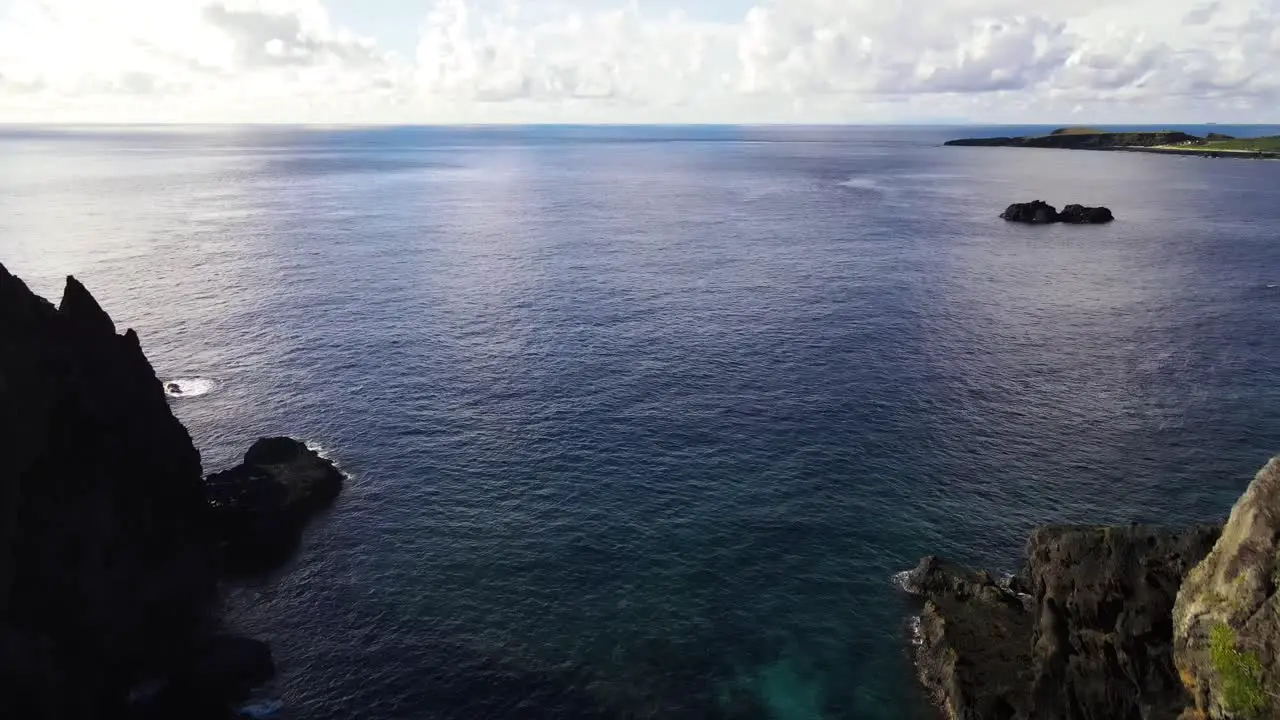 Flying through cliffs to reveal beautiful blue waters of pacific ocean