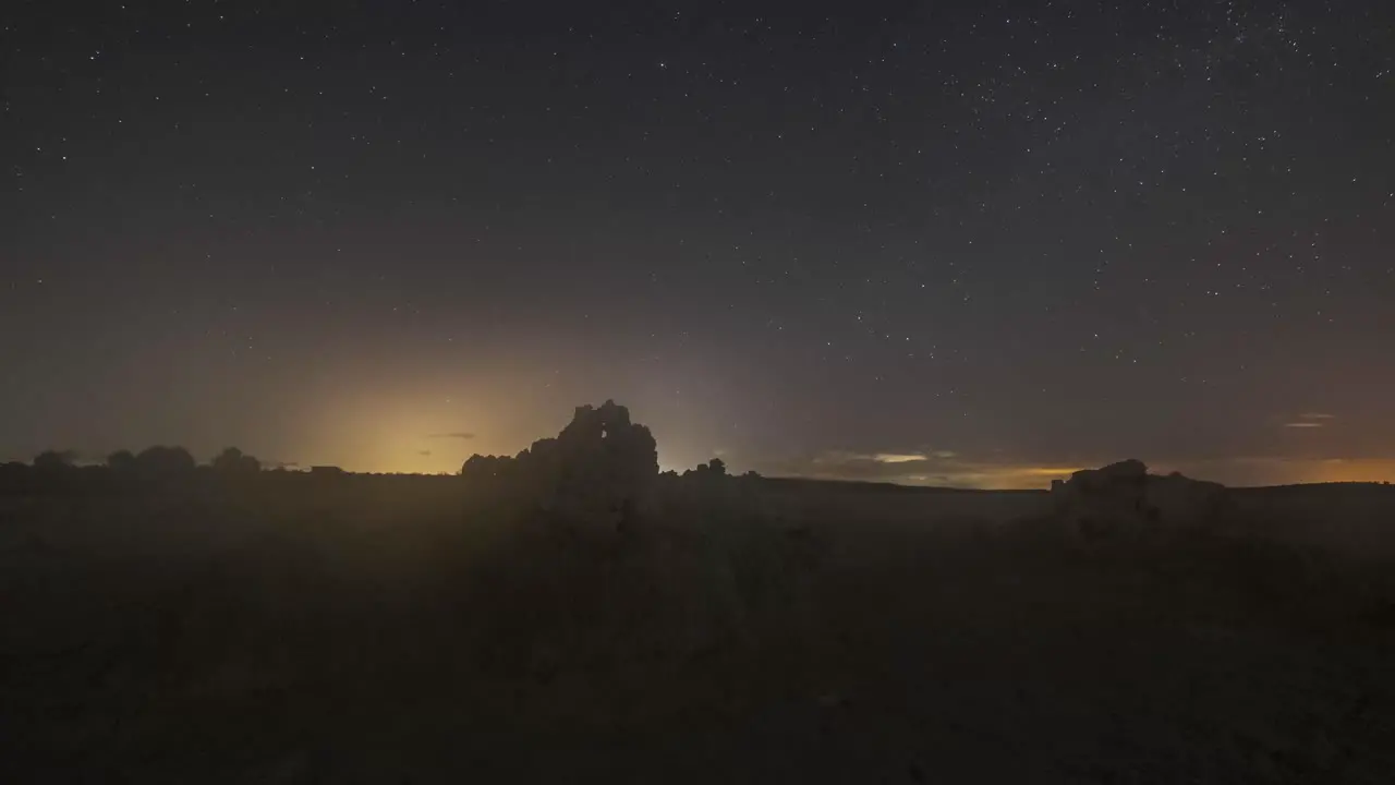 Starry sky with Milky Way above desert terrain