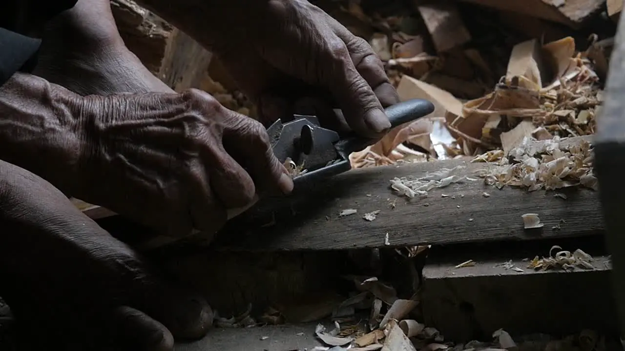 Close up on an old Muslim man working wood in the Traditional Sundanese village Kampung naga