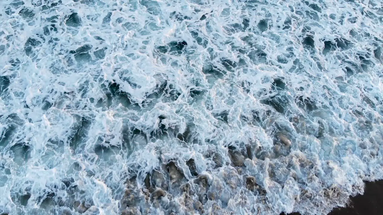 Top down shot of beautiful blue waves crashing onto the shore in Seal Beach CA