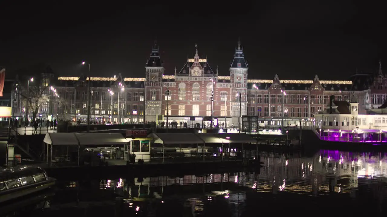 Centraal Station Amsterdam Netherlands train depot at night by canal lit up in the winter Central