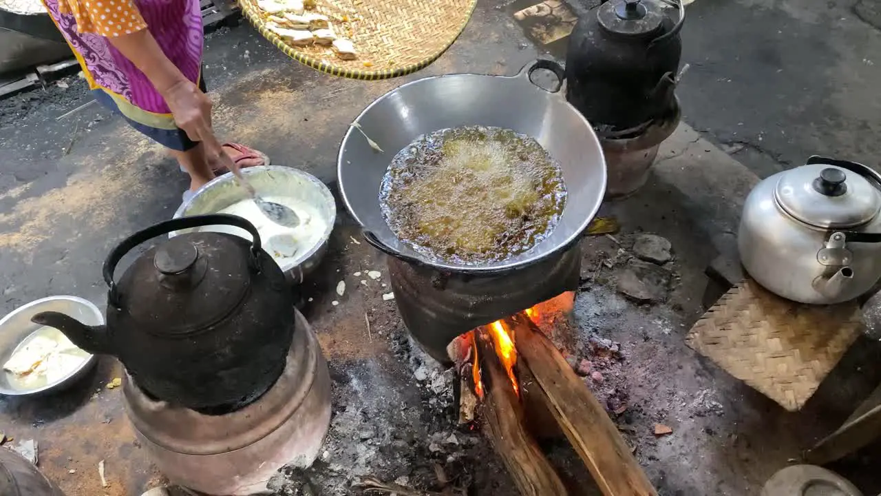 The process of cooking fried foods such as tofu tempeh in a traditional skillet and stove using coals and a stove-2