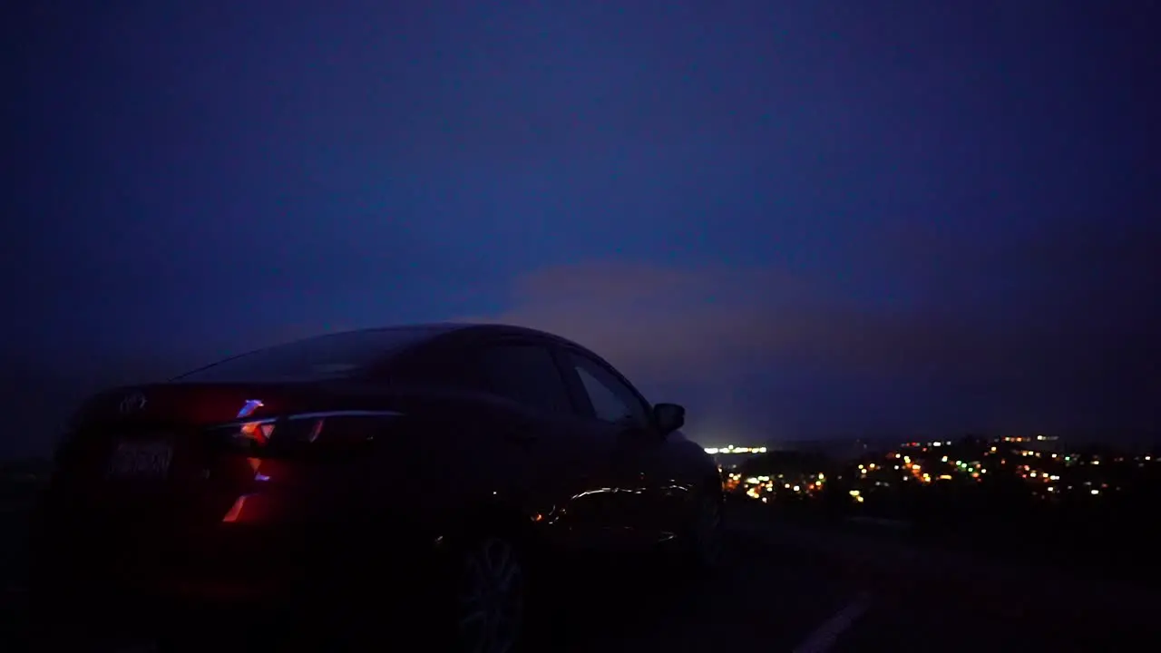 car parked on top of hill overlooking city at night