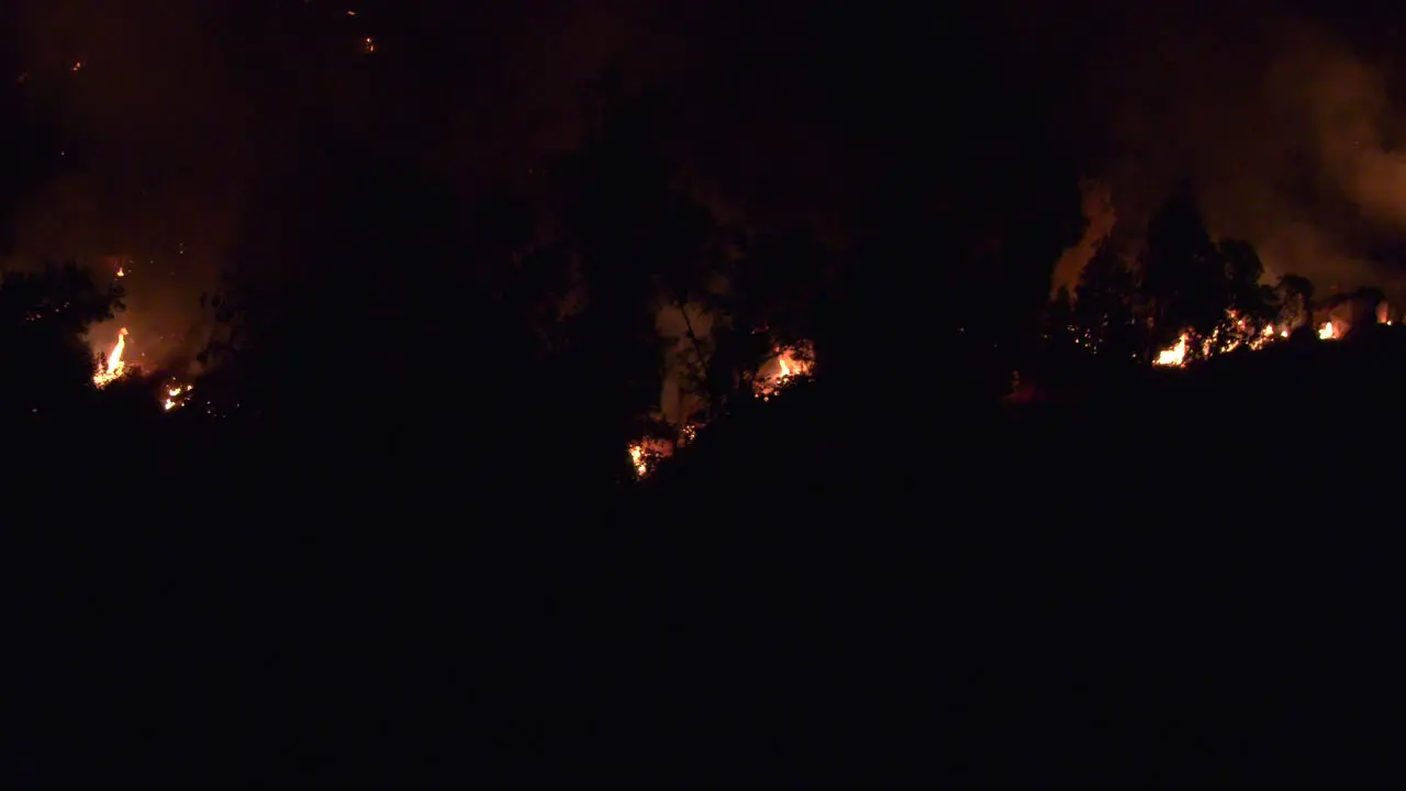 Flames consume large hillside at night