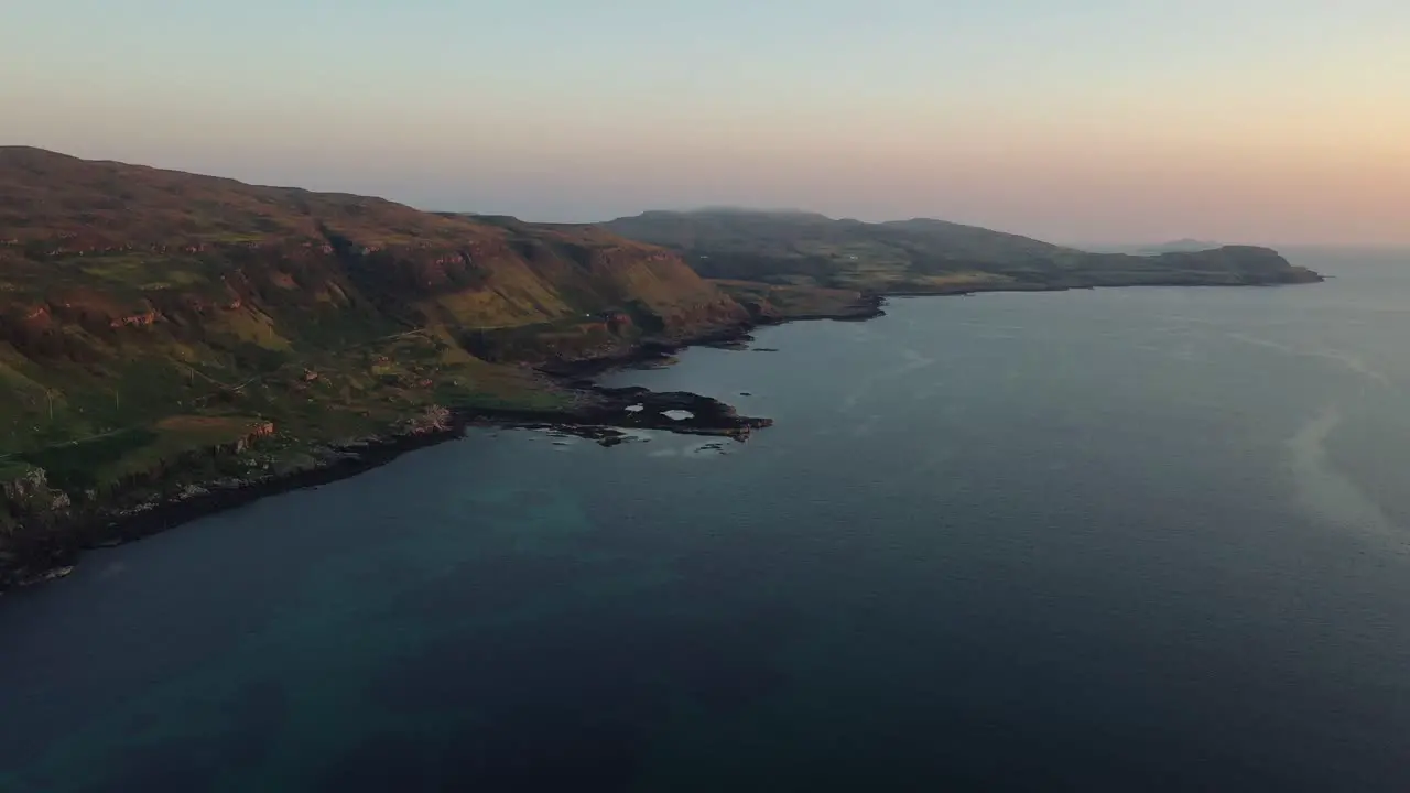 Slow Drone Across Calgary Beach Revealing Cliffs At Sunset