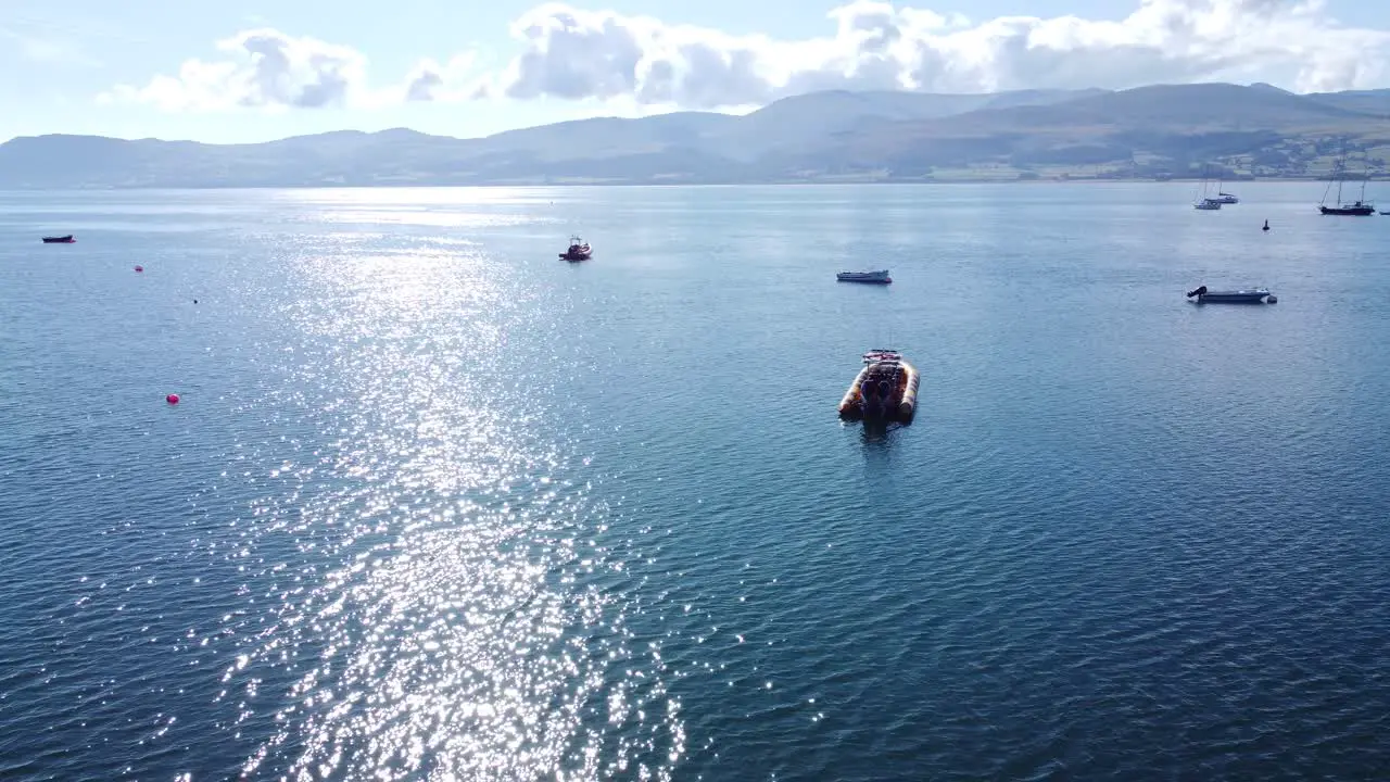 Snowdonia clear mountain range aerial view sunny calm Welsh shimmering seascape reversing right