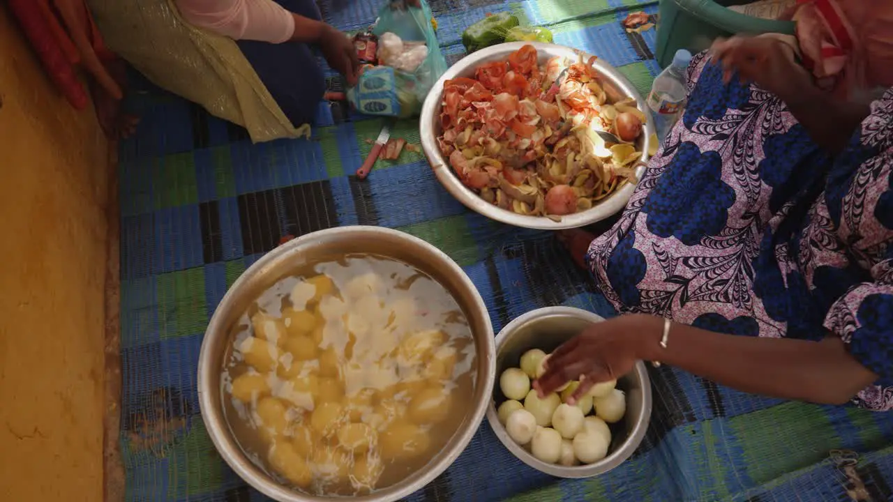 A shot from above of an african woman preparing food on the floor