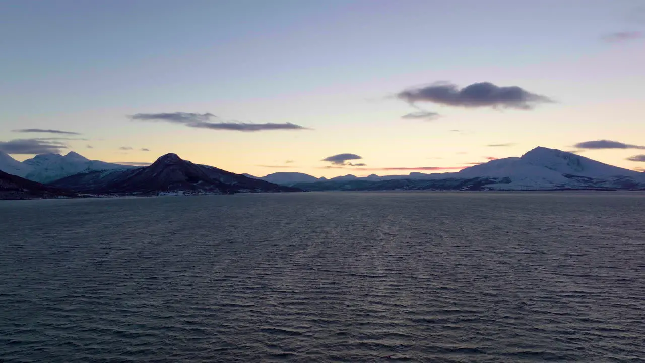 Beautiful sunset silhouetting a mountain range and the sea in Norway