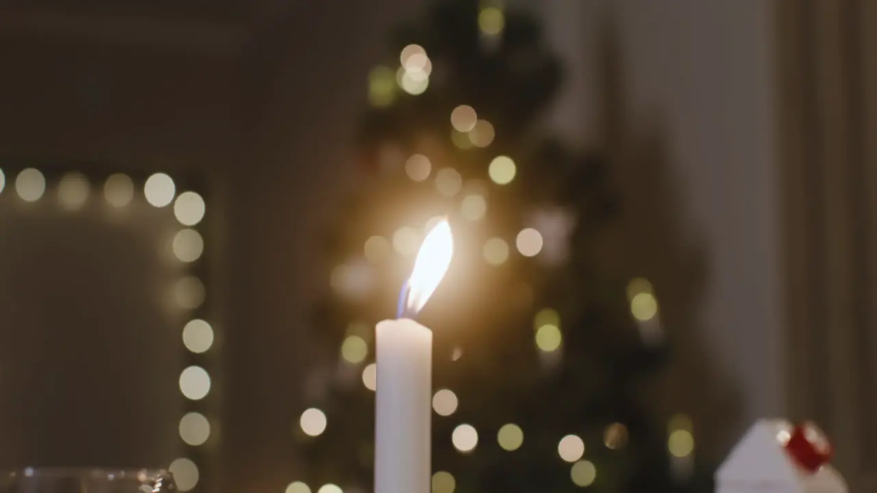 La Cámara Enfoca Una Vela Encendida Hay Un árbol De Navidad Con Luces Borrosas En El Fondo