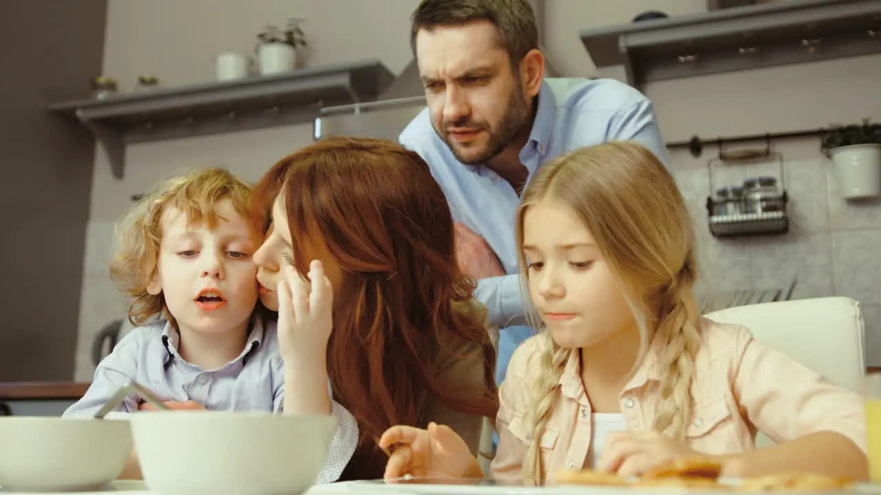 Family Having Breakfast And Using A Tablet In The Kitchen