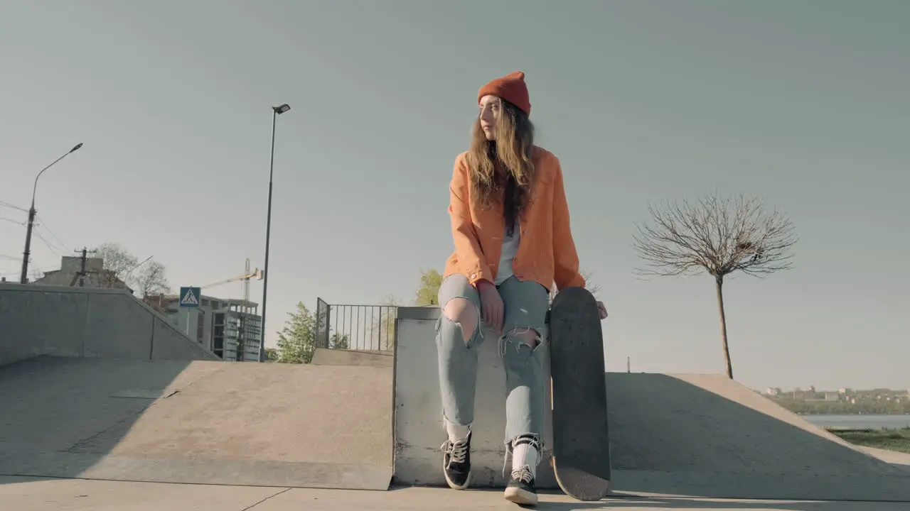 Chica Patinadora Esperando A Alguien Sentado En Un Parque De Patinaje