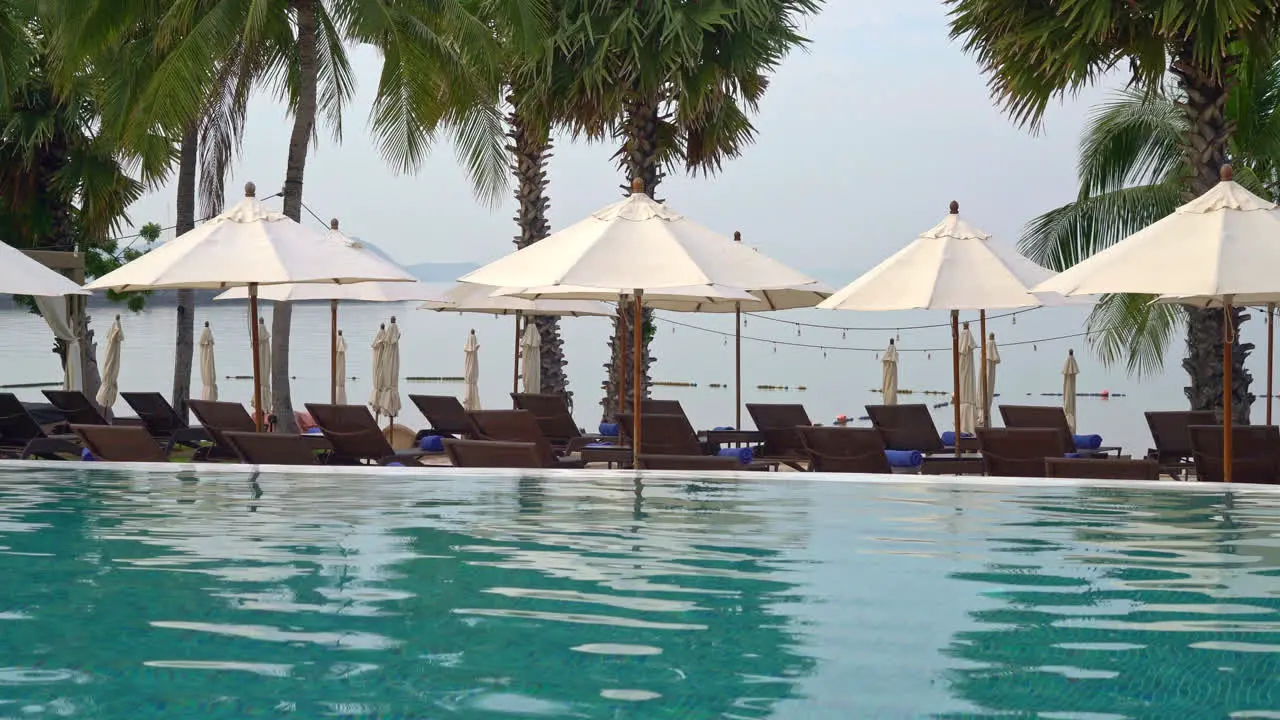 empty beach chair with umbrella around swimming pool