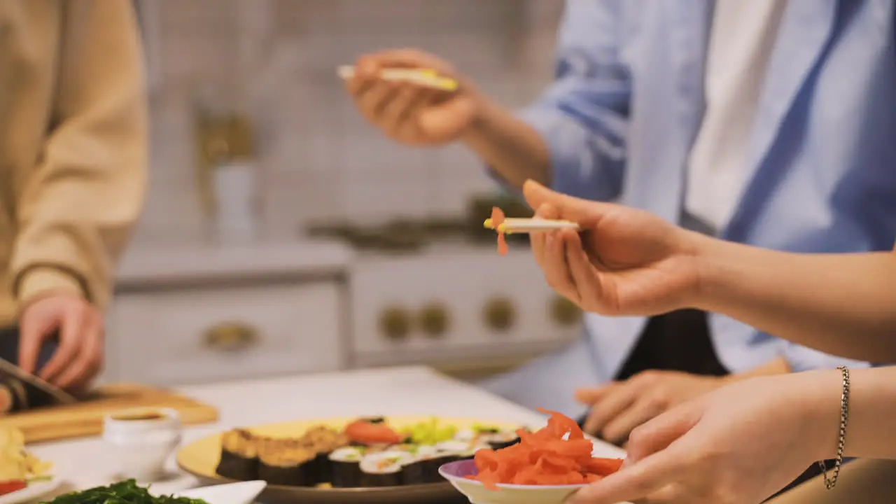 Close View Of A Plate Of Sushi And Hands Holding Japanese Chopsticks