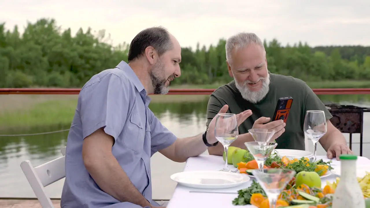 Two Men Having Dinner Or Lunch Outdoors