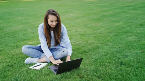 Woman student working on laptop computer in college campus Freelance work