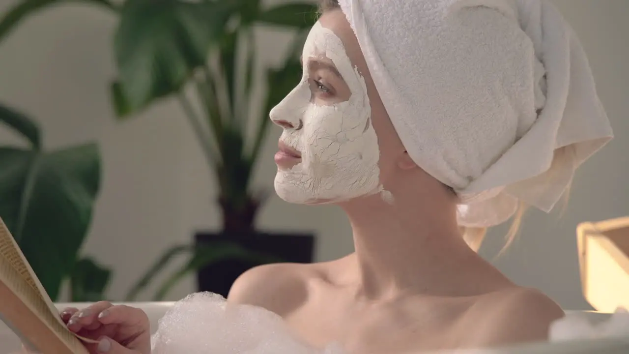 Portrait Of Female With Face Mask Taking A Relaxing Bath And Reading