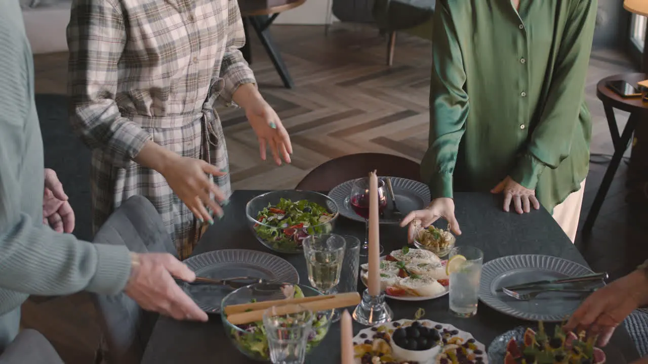 Unrecognizable Family Standing Near The Table In Living Room And Being Ready To Have Meal Together