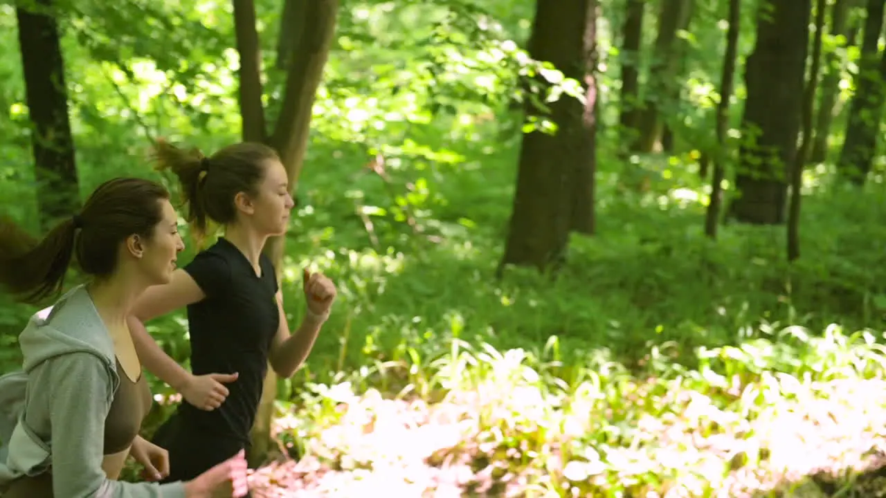 Two Sportswomen Running Through The Woods