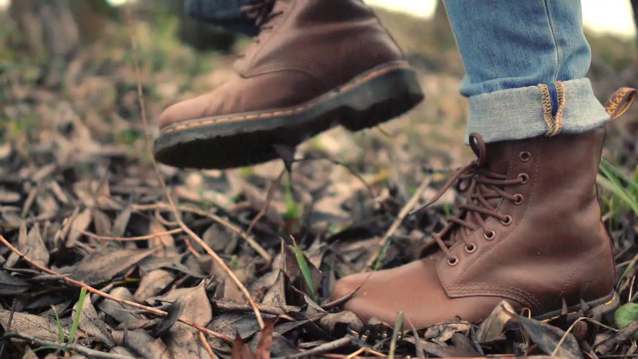 Walking legs in brown shoes side view Walking feet in brown leather boots