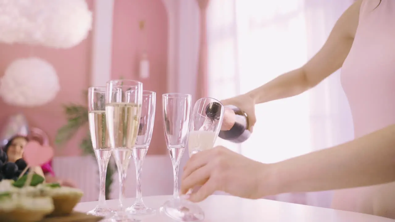 Close Up View Of A Woman Pouring Champagne In Crystal Glasses On The Table