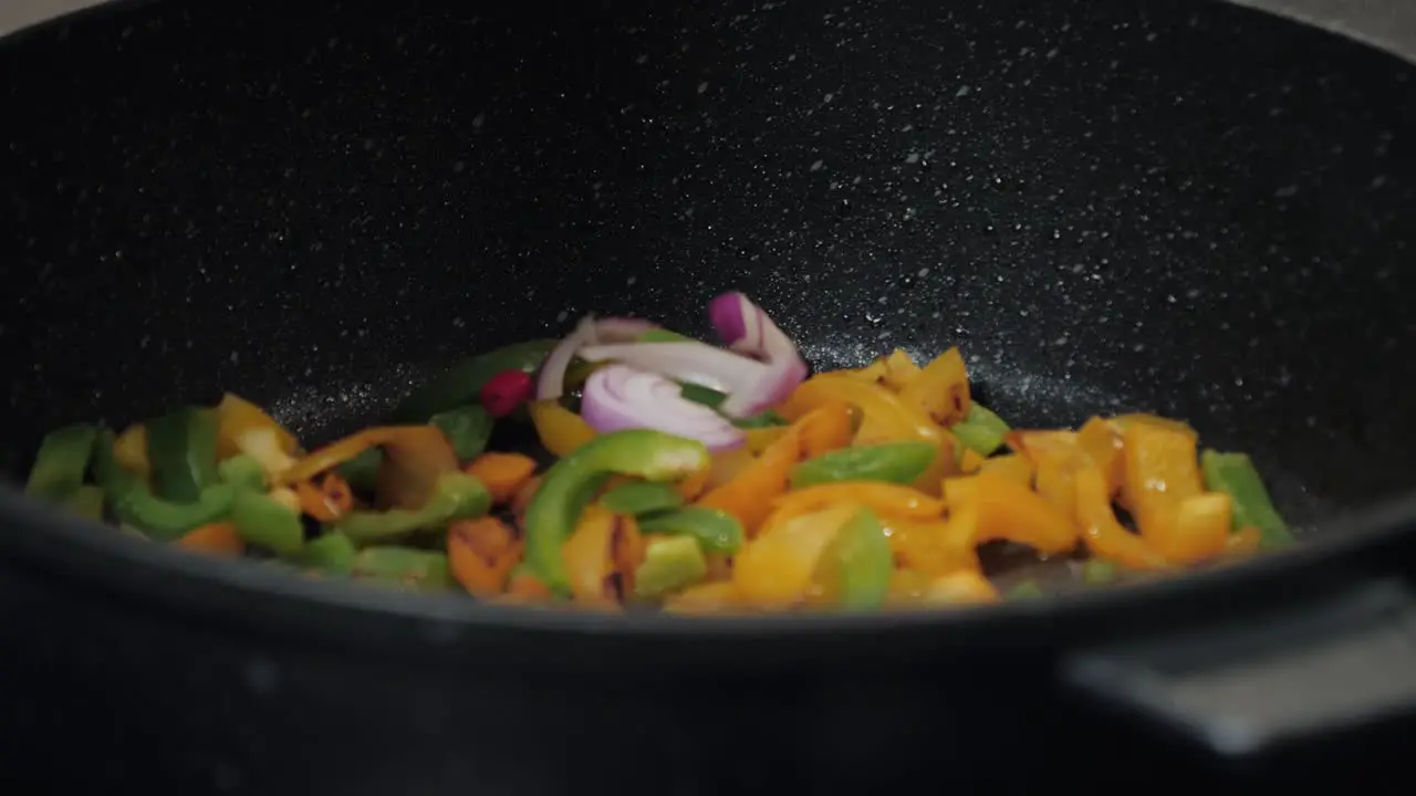 Motion controlled slow motion shot of paprika in a cooking pan