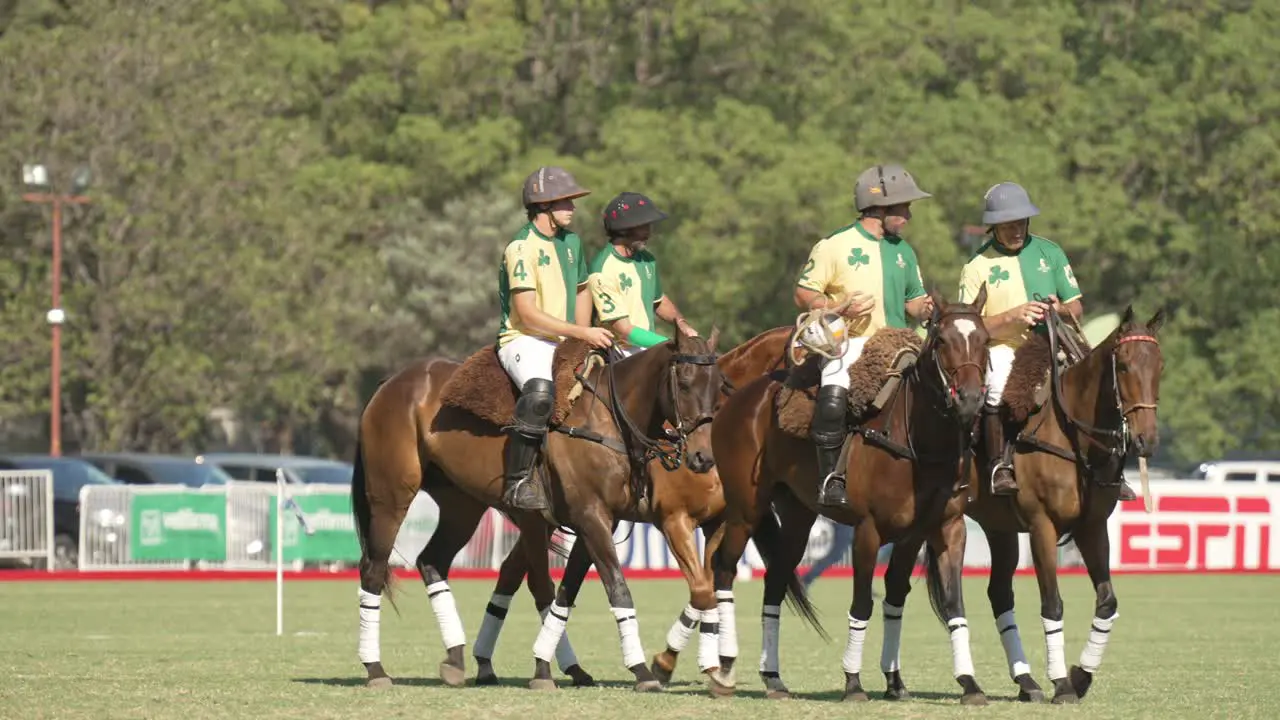 Four Pato team members on horseback chatting strategy for upcoming game