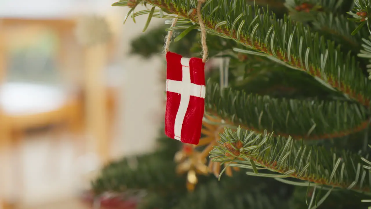 Danish flag ornament hanging on a festive Christmas tree