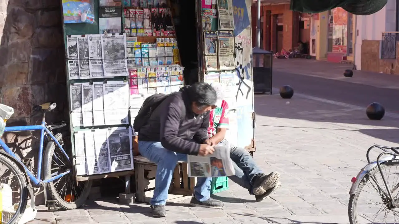 Newspaper and magazine sales reading the news at newspaper stand