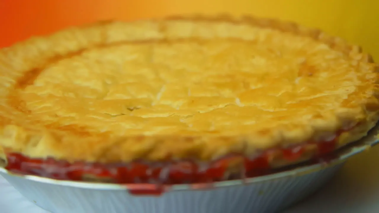 [Camera Used Canon C300] A rotating cherry pie with golden crust and cherry glaze oozing out the sides