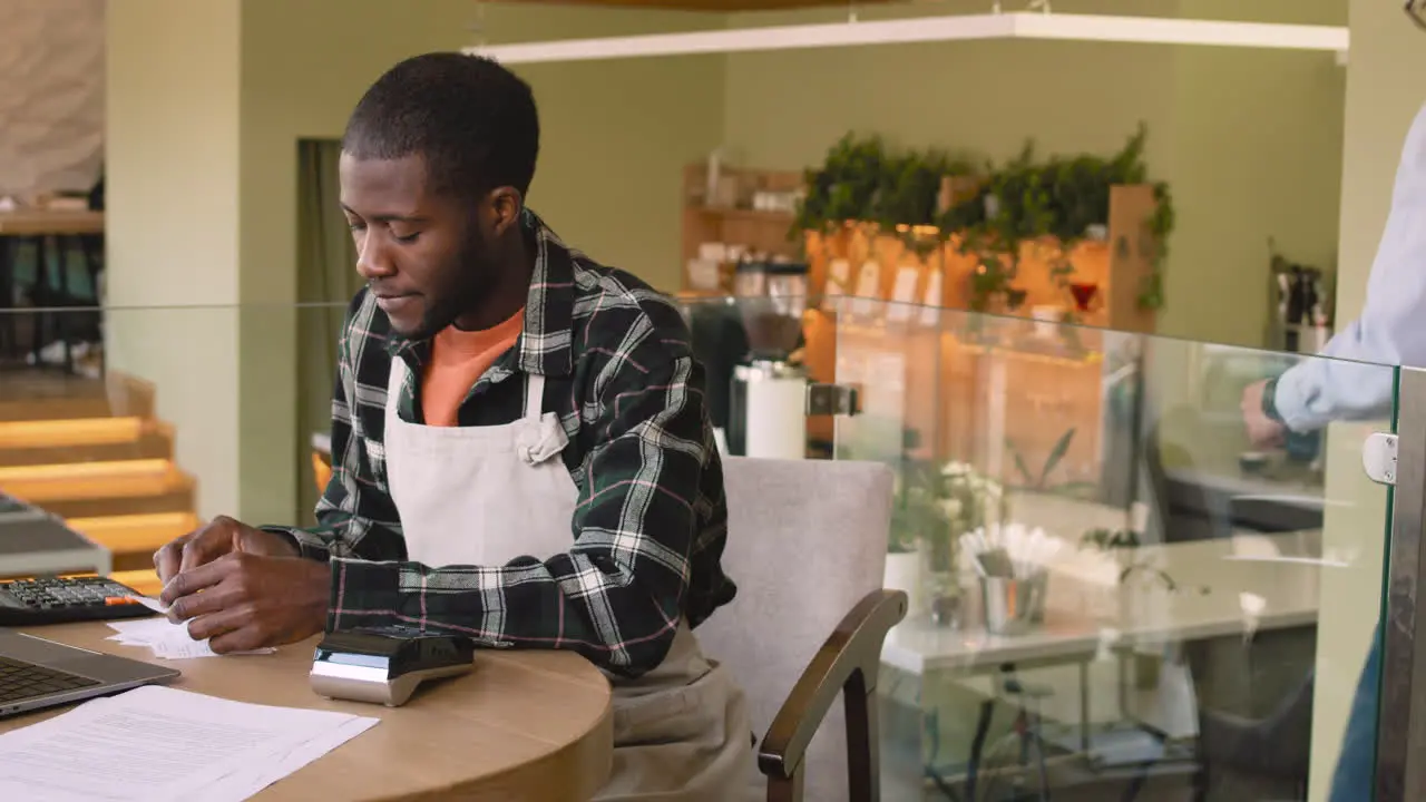 Two Multiethnic Coffee Shop Owners Calculating Finance Bills On Laptop Computer 1