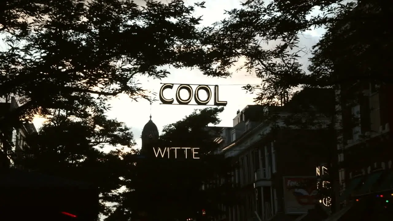 neon art sign "cool" hanging across the street