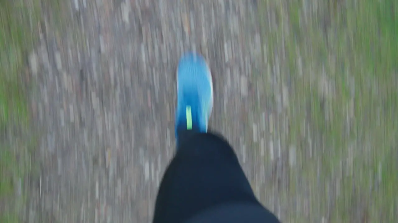 First-Person-View Runner's feet jogging on a trail on a cloudy day