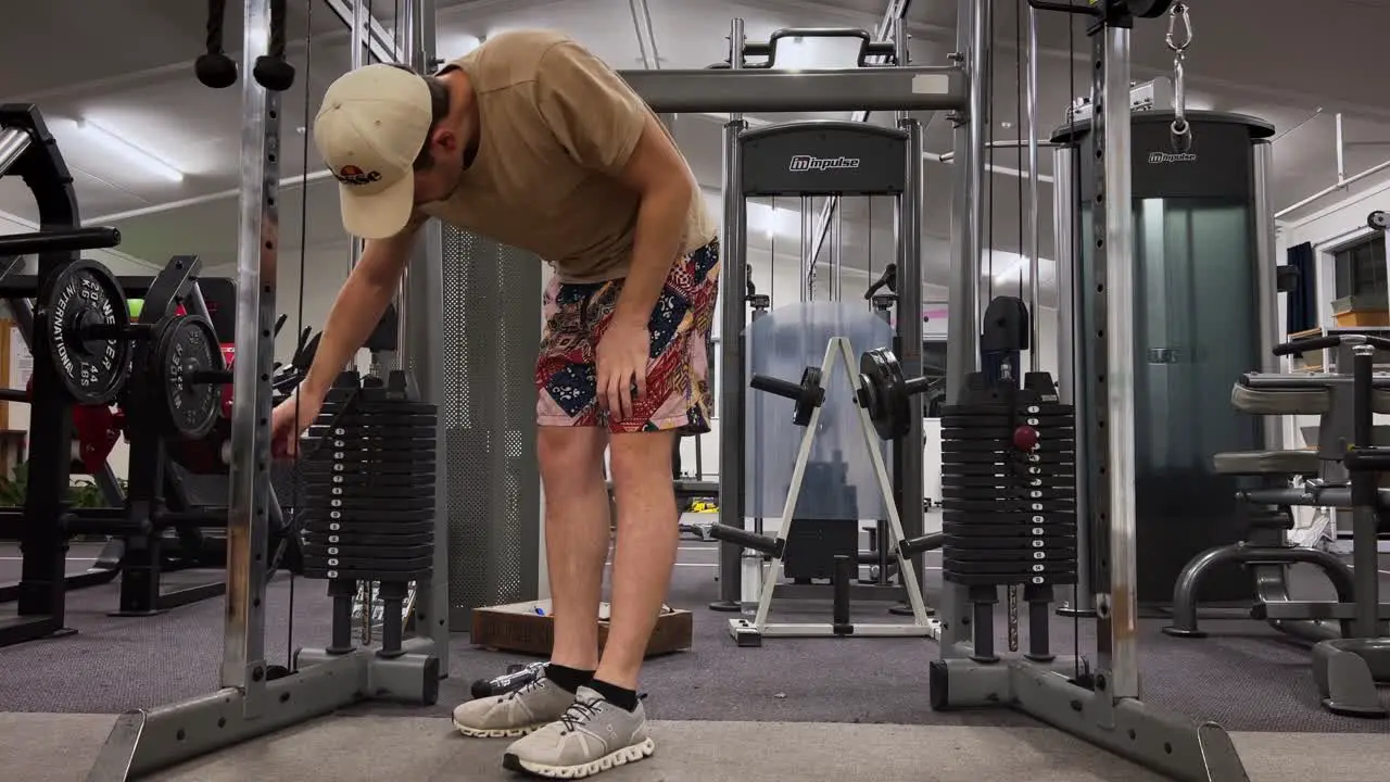 Man in shorts doing triceps extension exercise in gym