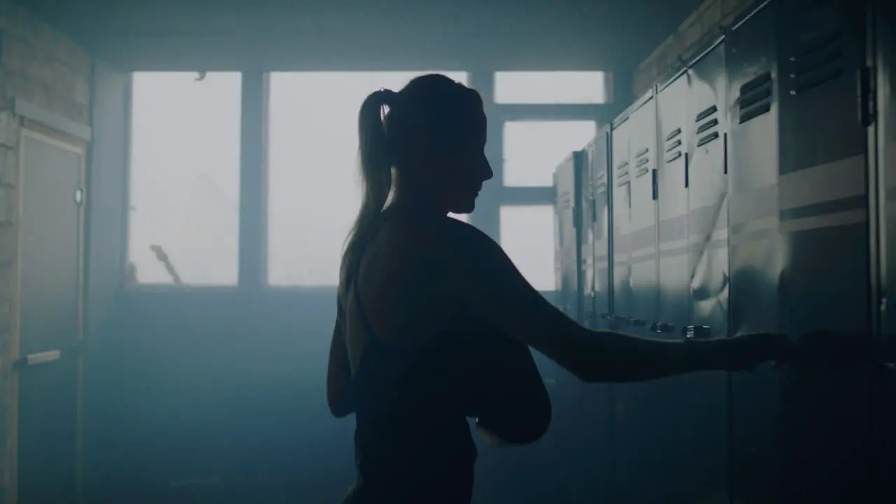 Woman Putting Boxing Gloves in Locker 01