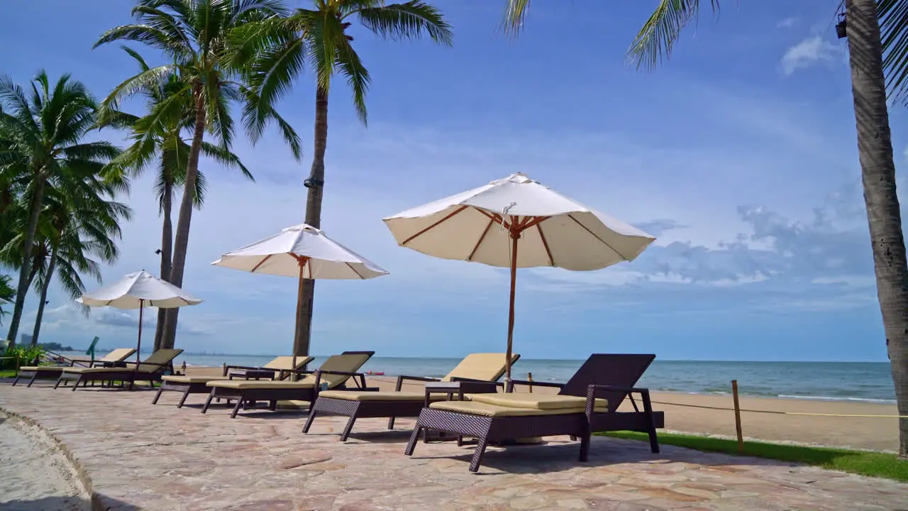 umbrella and beach chair with coconut palm tree and sea beach background and blue sky holiday and vacation