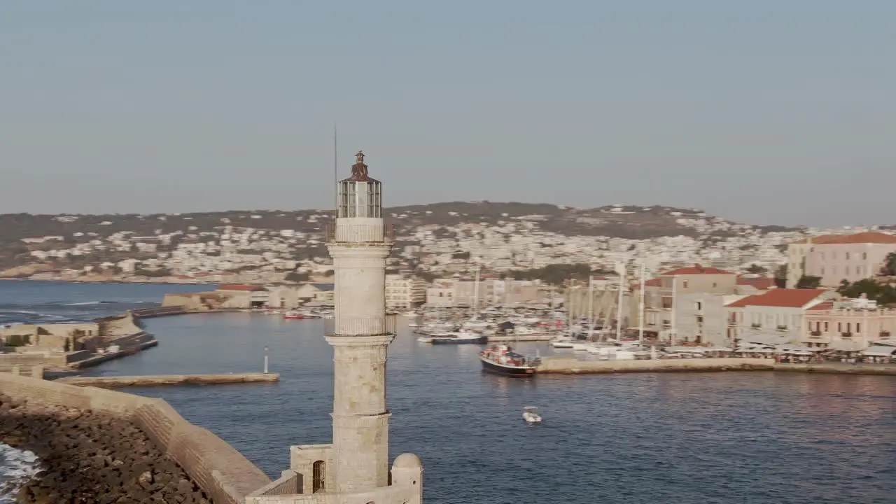 Lighthouse of Chania city with cityscape view drone orbit shot