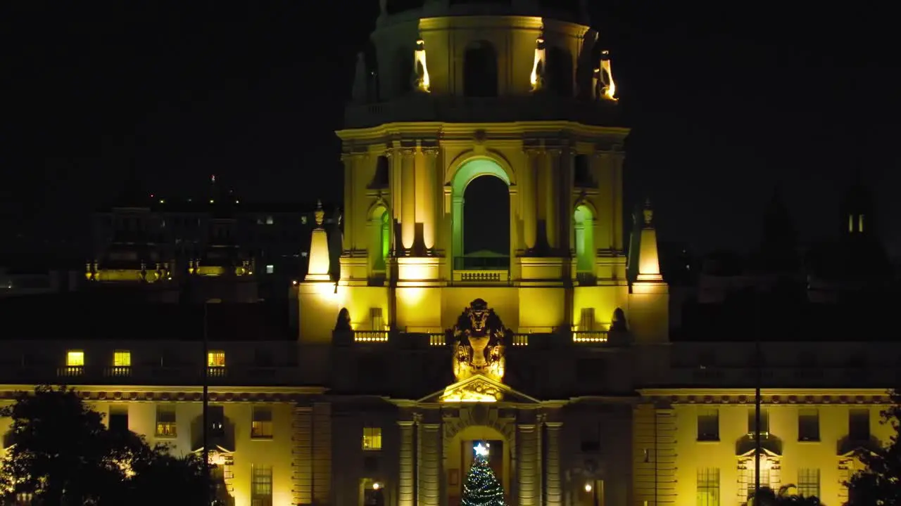 Establishing view of Pasadena City Hall at night during Christmas Holiday Season rising aerial view