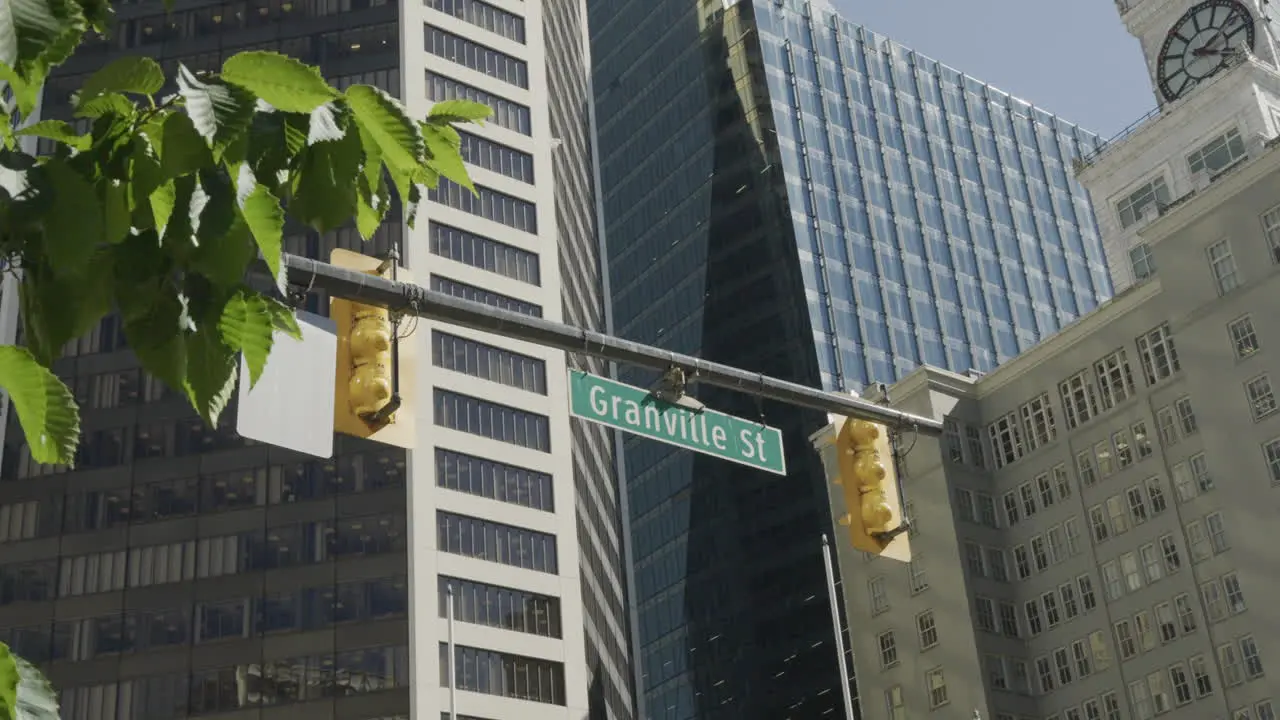 Granville Street crossing in Vancouver street sign with buildings in the background handheld parallax