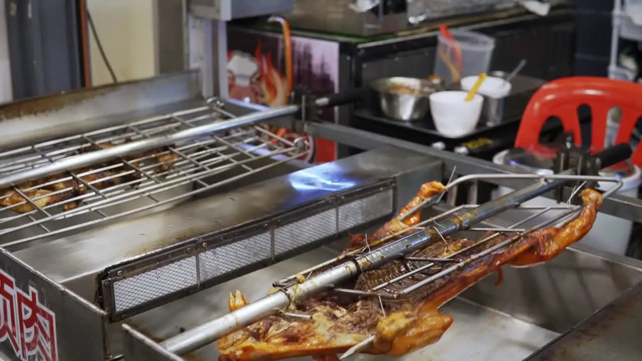 A pig and other foods rotate on a rotisserie spit in a restaurant