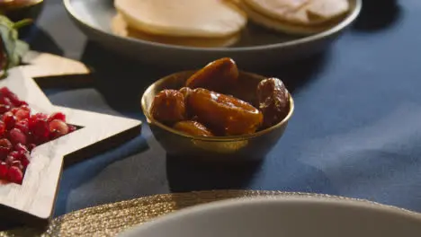 Person Eating Dates At Muslim Family Table At Home Set For Iftar Meal Breaking Daily Fast During Ramadan 1