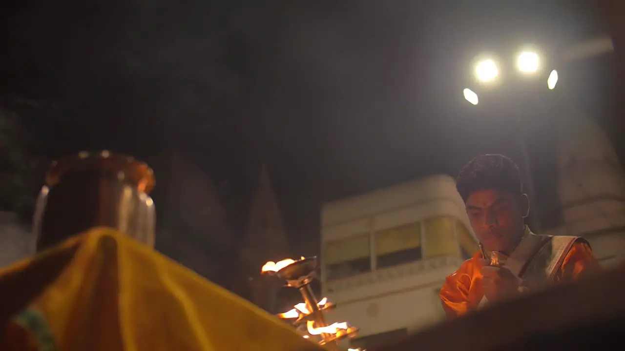 Man Waves Ceremonial Candelabra and Rings Bell