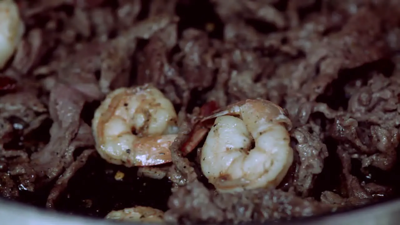 Sizzling Shrimp and steak cooking on stove in pan Dinner