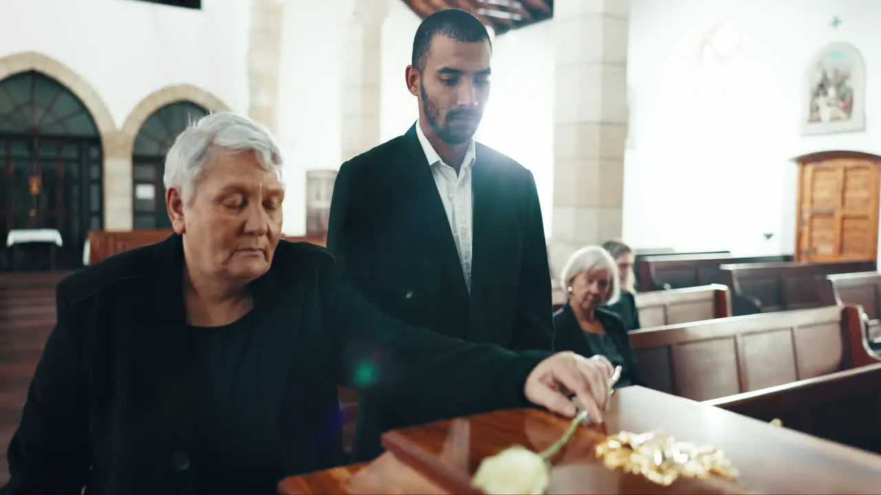 Funeral coffin and senior woman with flower